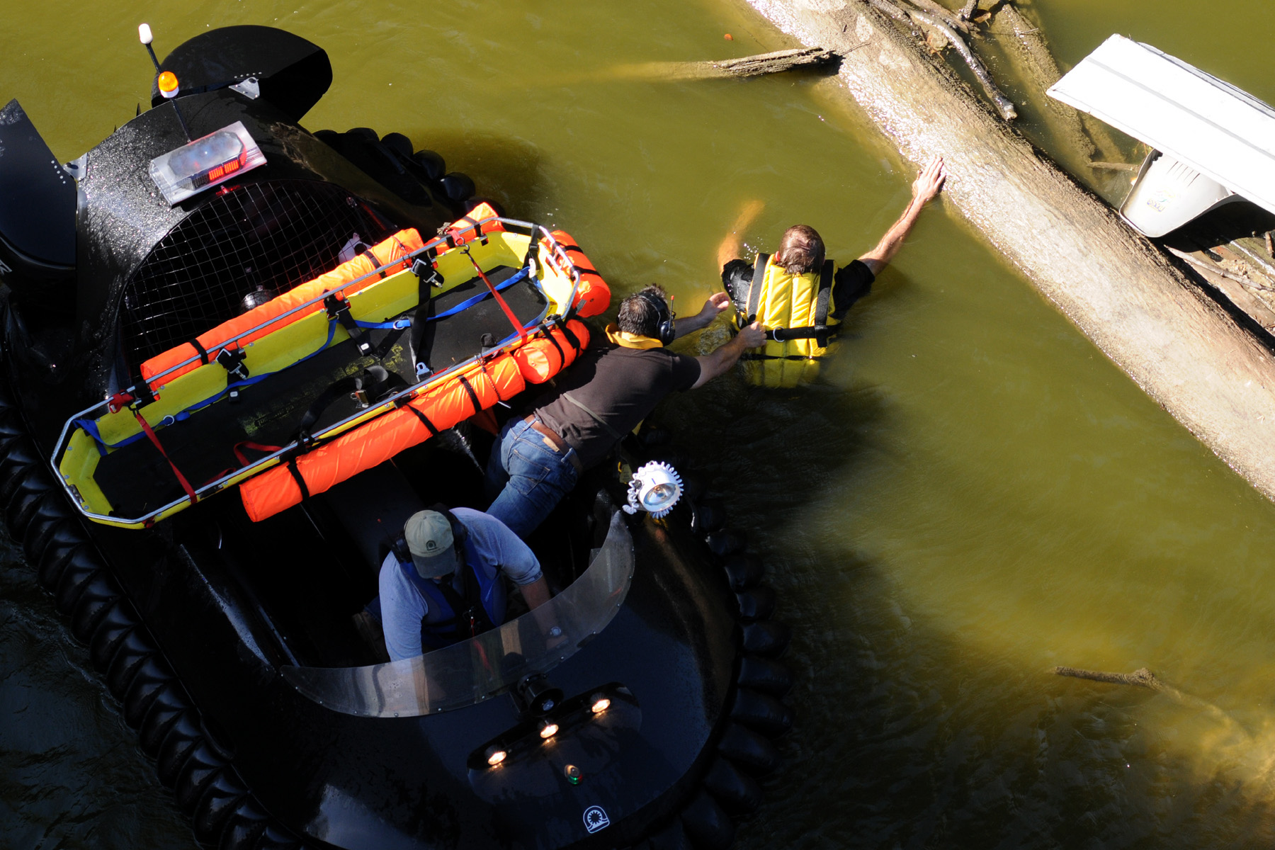 Hovering close to the victim clasping to a floating log.