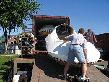 Pushing the hovercraft kit into the container with great caution to avoid damage.